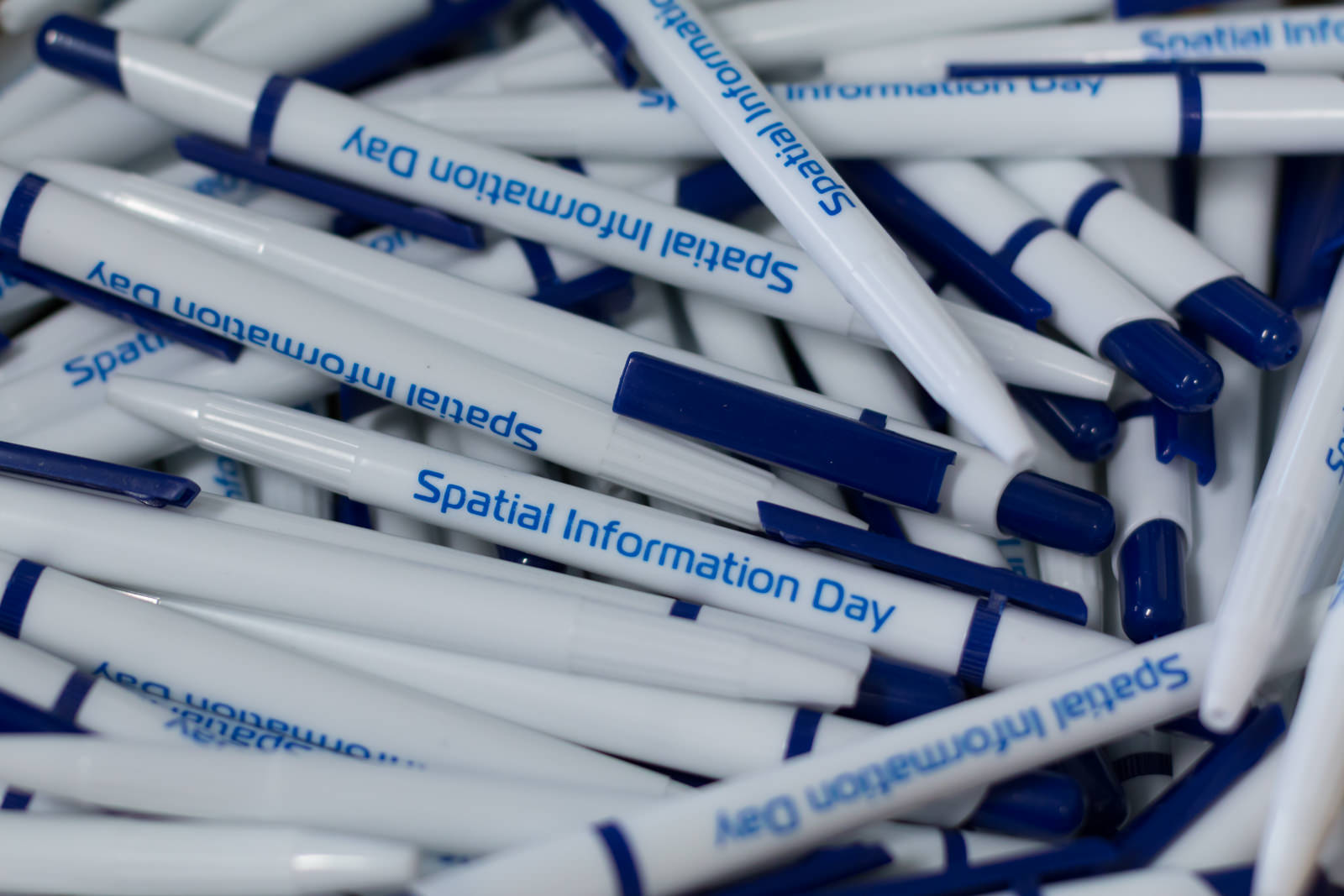 Photo of pens with Spatial Information Day logo on them